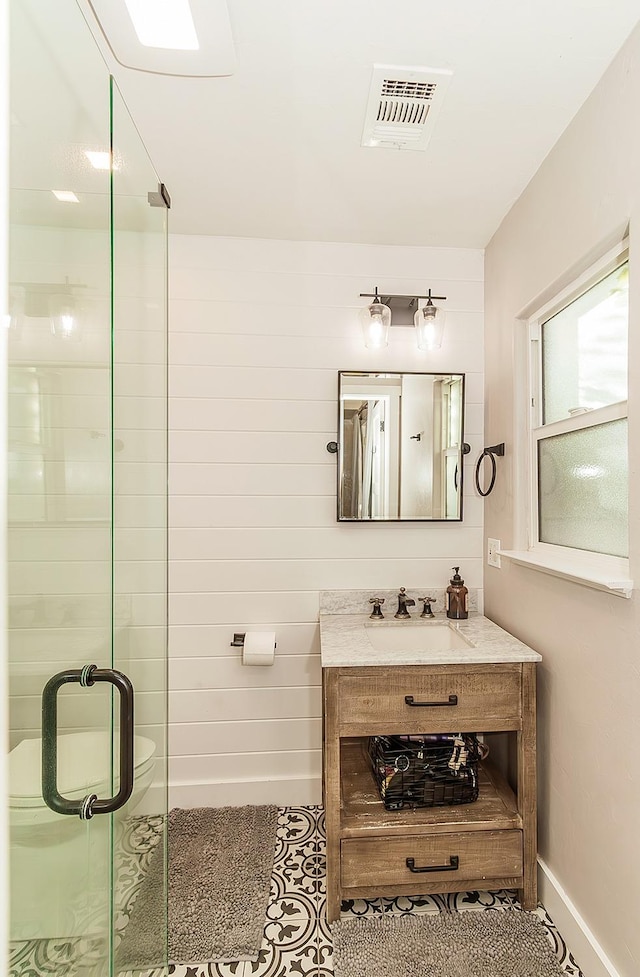 bathroom featuring a stall shower, baseboards, visible vents, and vanity