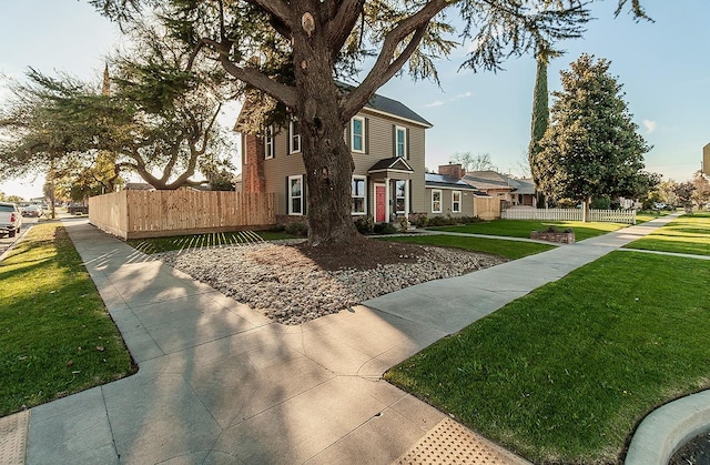 view of side of property featuring a residential view, a yard, and fence