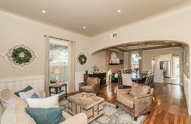 living room featuring visible vents, arched walkways, dark wood finished floors, and recessed lighting