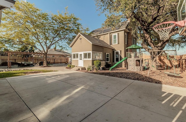 exterior space with entry steps, a patio area, a playground, and fence