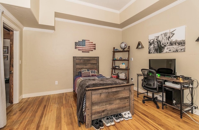 bedroom featuring light wood finished floors, baseboards, and ornamental molding