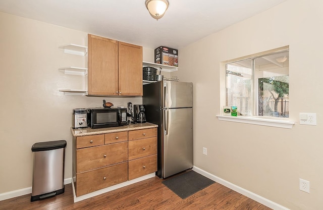 kitchen with dark wood-style floors, open shelves, freestanding refrigerator, black microwave, and baseboards