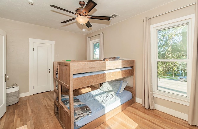 bedroom featuring light wood-type flooring, visible vents, and baseboards