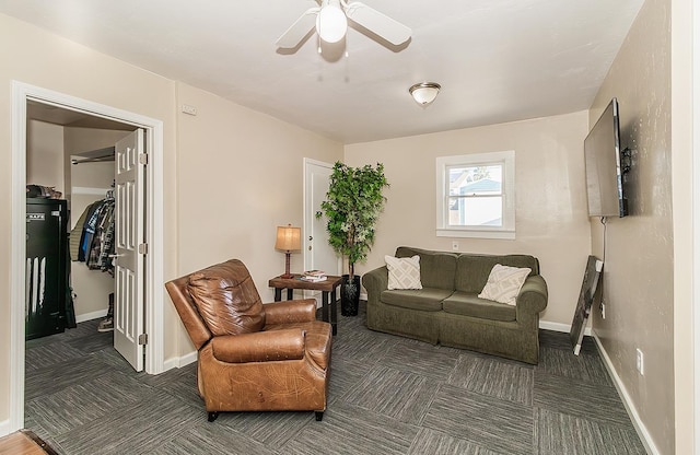 carpeted living area featuring baseboards and a ceiling fan