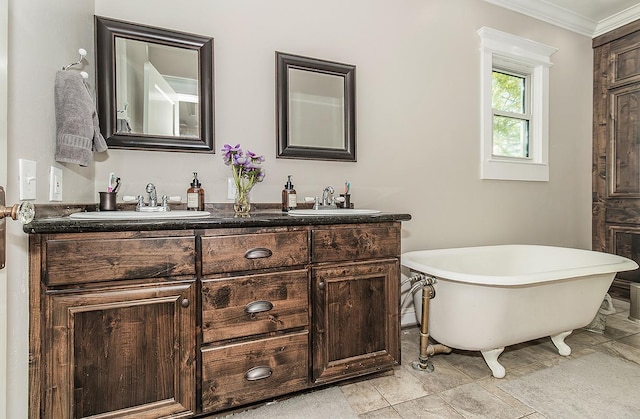 bathroom featuring double vanity, a freestanding tub, crown molding, and a sink