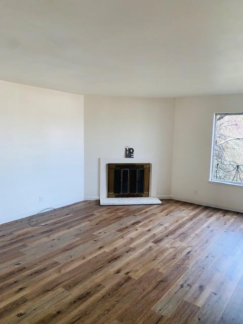 unfurnished living room featuring wood finished floors