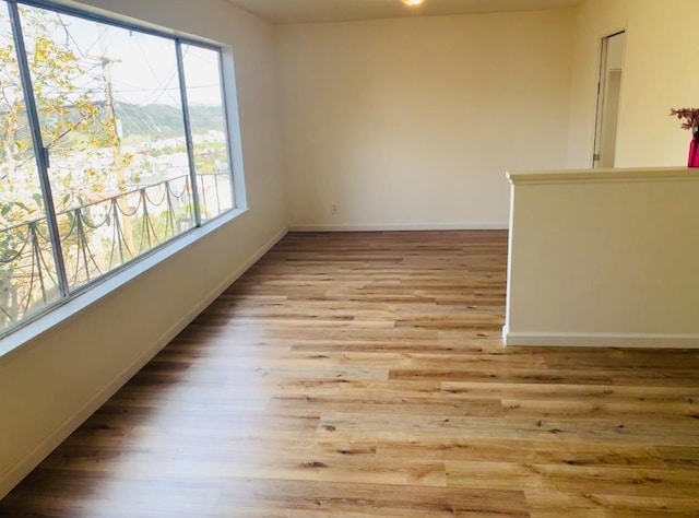 empty room with baseboards and wood finished floors