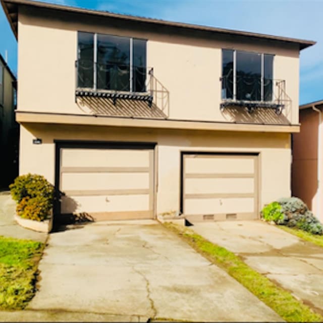 view of front of property featuring an attached garage and stucco siding