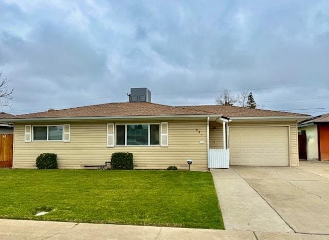 single story home featuring a garage, concrete driveway, fence, and a front lawn