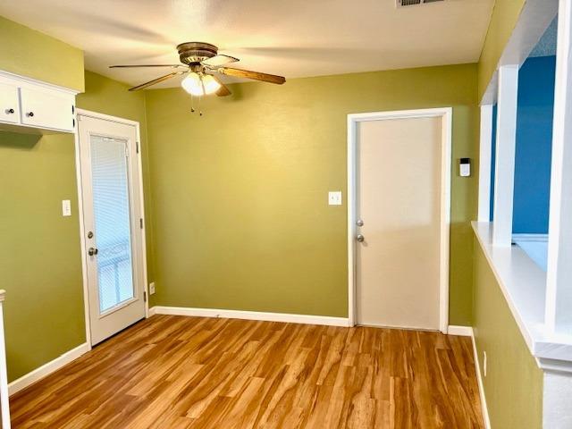 interior space with light wood finished floors, visible vents, baseboards, and a ceiling fan