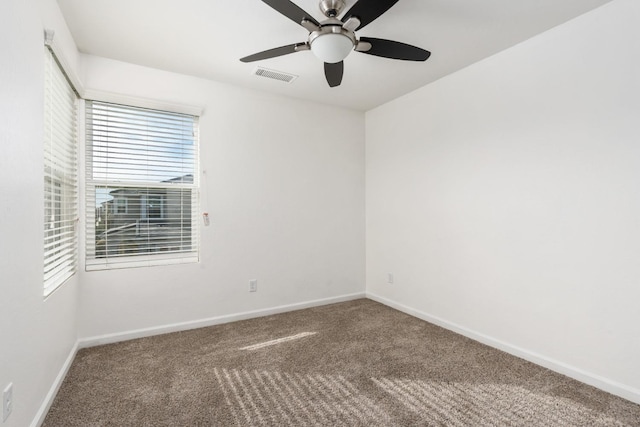 carpeted empty room with visible vents, ceiling fan, and baseboards