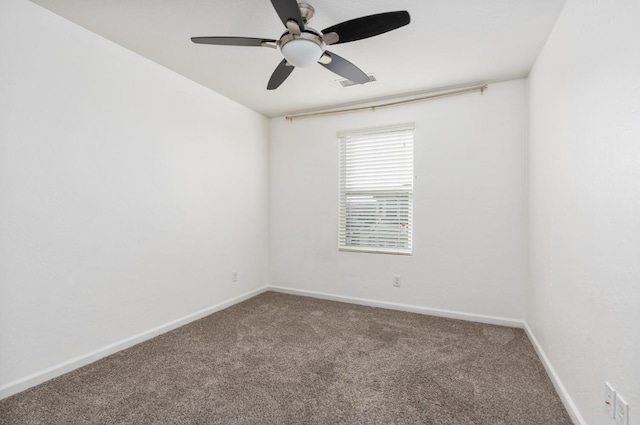 carpeted spare room with visible vents, ceiling fan, and baseboards