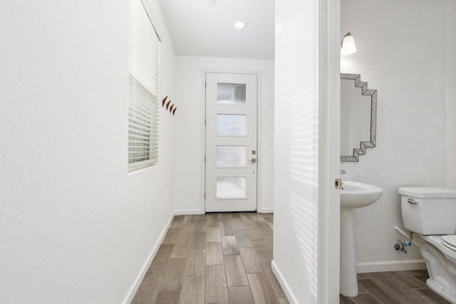 entryway featuring stairs, baseboards, and wood finished floors