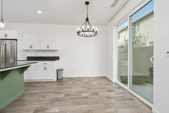 unfurnished dining area featuring visible vents, baseboards, light wood-type flooring, a notable chandelier, and recessed lighting