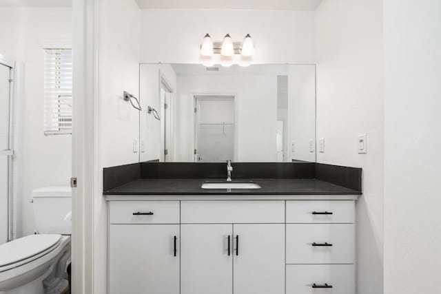 full bath featuring an enclosed shower, vanity, and toilet