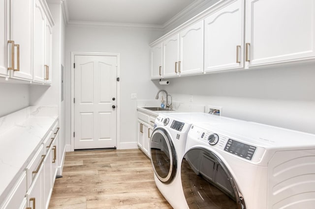 laundry room with washing machine and dryer, light wood-style flooring, a sink, cabinet space, and crown molding