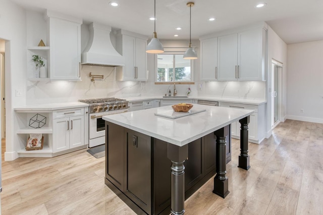 kitchen with a sink, white cabinets, open shelves, gas range oven, and custom range hood