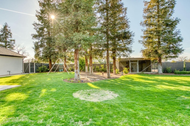 view of yard featuring a pole building, a playground, an outdoor structure, and a fenced backyard