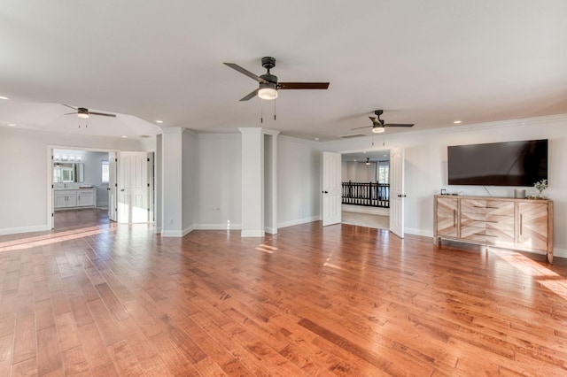 unfurnished living room with ornamental molding, light wood finished floors, recessed lighting, and baseboards