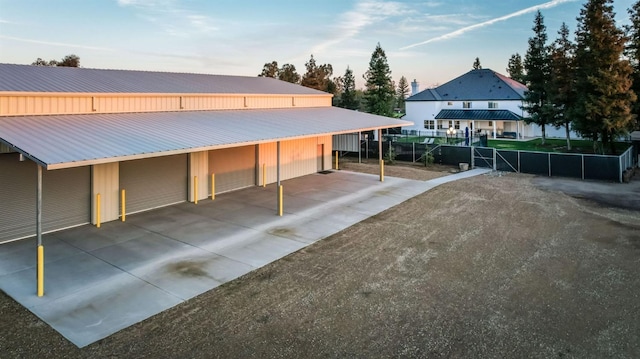 view of car parking with a garage and fence