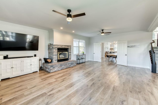 unfurnished living room with ornamental molding, a fireplace, light wood-style flooring, and baseboards