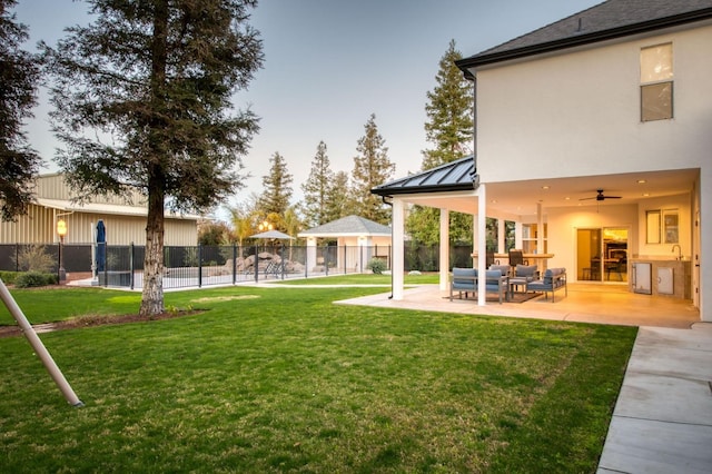 view of yard featuring an outdoor hangout area, a patio area, fence, and a ceiling fan