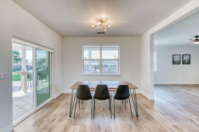 dining room with baseboards, light wood-style flooring, visible vents, and a healthy amount of sunlight