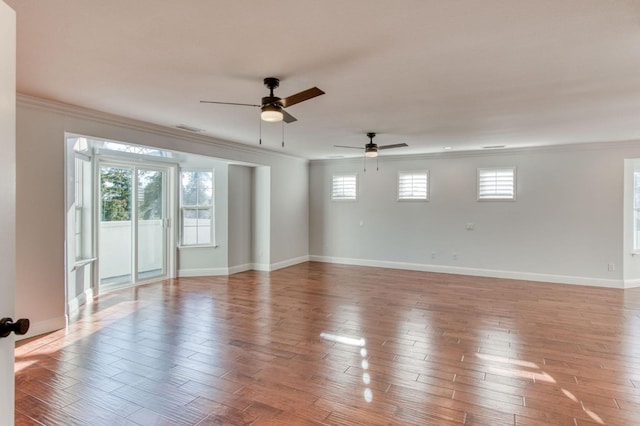 spare room featuring ornamental molding, wood finished floors, visible vents, and baseboards