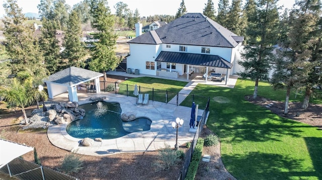 rear view of property with a patio, a lawn, a gazebo, a standing seam roof, and fence private yard