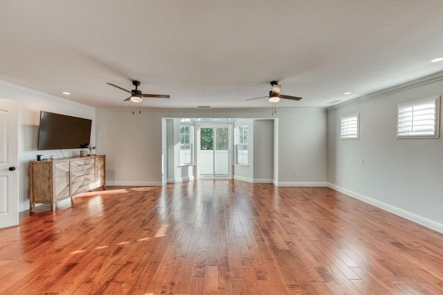 unfurnished living room featuring ornamental molding, light wood-type flooring, and baseboards