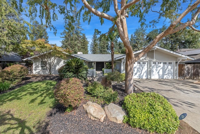 view of front of home featuring a garage, a front yard, and driveway