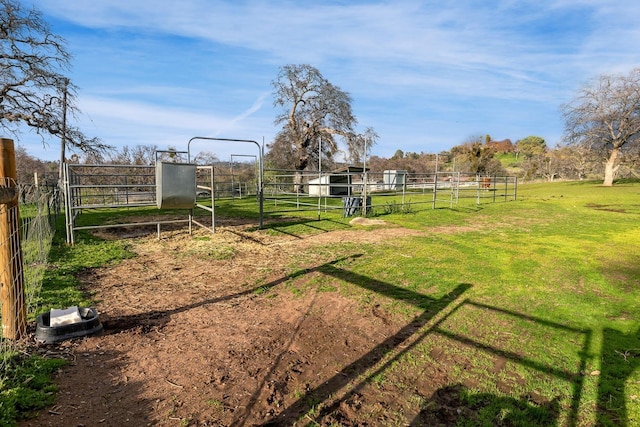 view of yard with a rural view, an outdoor structure, and an exterior structure