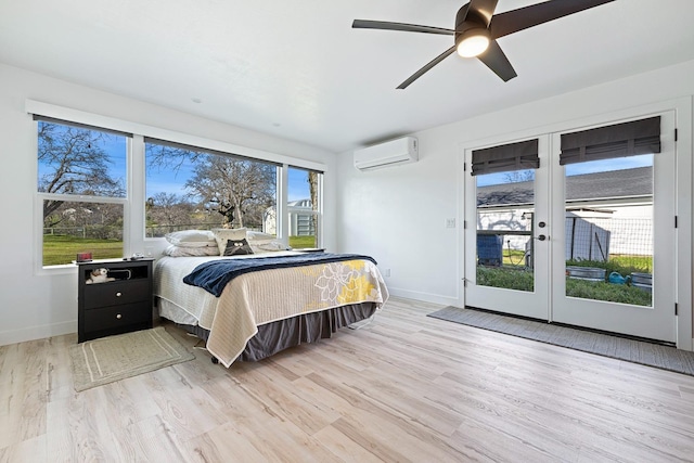 bedroom with light wood-style floors, access to outside, an AC wall unit, and baseboards