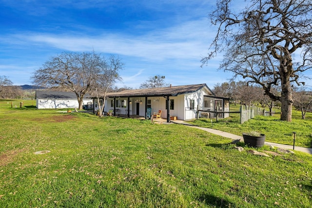 back of house featuring covered porch and a yard