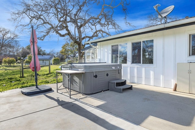 view of patio / terrace featuring fence and a hot tub