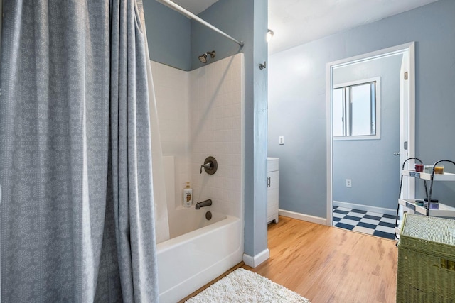 full bathroom featuring shower / tub combo and baseboards