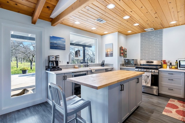 kitchen with visible vents, butcher block countertops, appliances with stainless steel finishes, and gray cabinetry