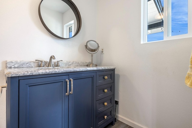 bathroom featuring wood finished floors, vanity, and baseboards