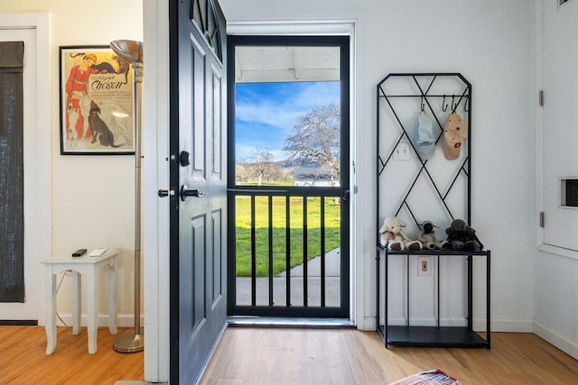 doorway featuring wood finished floors and baseboards