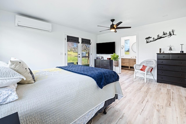 bedroom featuring ceiling fan, access to exterior, light wood-type flooring, a wall mounted air conditioner, and ensuite bath