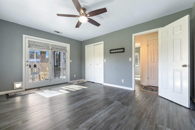 unfurnished bedroom with dark wood-style floors, access to exterior, a closet, visible vents, and baseboards