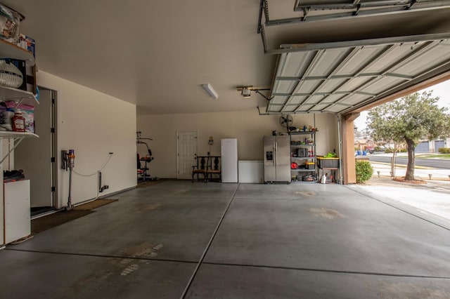 garage featuring stainless steel refrigerator with ice dispenser