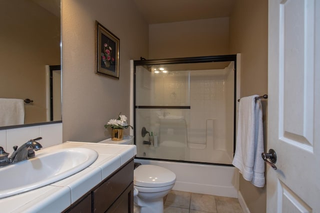 full bathroom with tile patterned flooring, shower / bath combination with glass door, vanity, and toilet