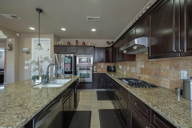 kitchen with under cabinet range hood, a sink, visible vents, appliances with stainless steel finishes, and tasteful backsplash