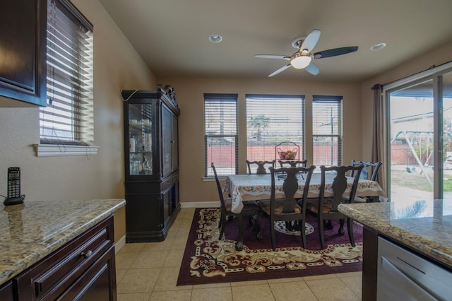 dining space with a ceiling fan, a healthy amount of sunlight, baseboards, and light tile patterned flooring