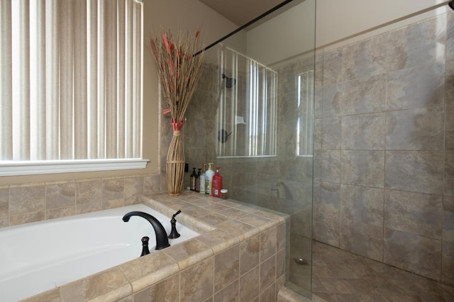 bathroom featuring a stall shower and a bath