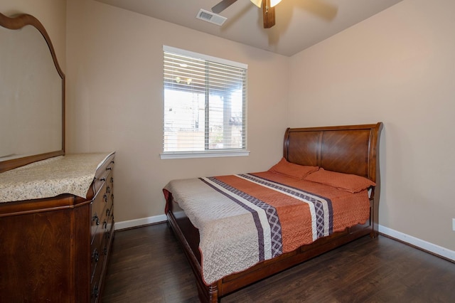 bedroom with dark wood-style floors, visible vents, and baseboards