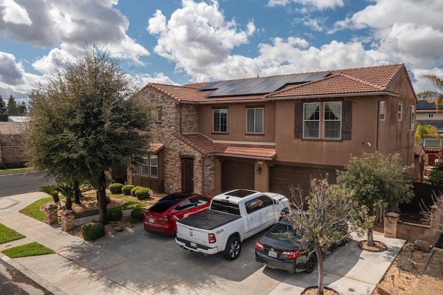 view of front of house featuring driveway, stucco siding, stone siding, and a tiled roof