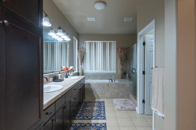 full bathroom featuring a sink, visible vents, a shower stall, a bath, and tile patterned floors