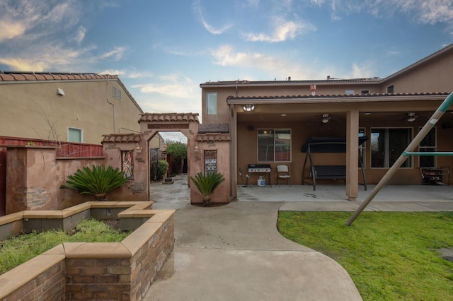 back of property featuring a ceiling fan, stucco siding, a patio, and fence